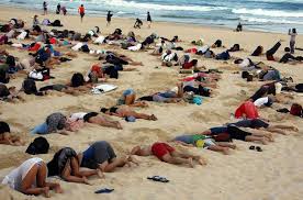 Australians bury heads in sand to mock government climate stance - Reuters