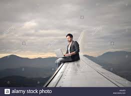 Man with laptop sitting on airplane's wing Stock Photo - Alamy